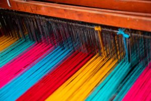 Strands of colorful yarn in a loom