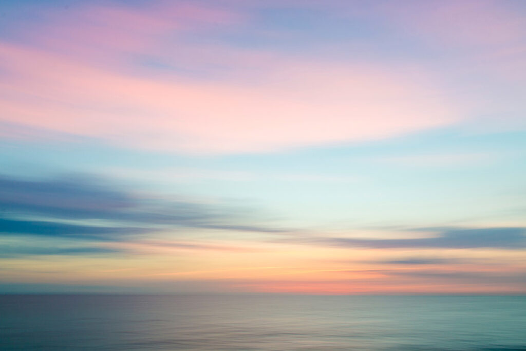 Abstract sunset sky and ocean nature background with blurred panning motion.
